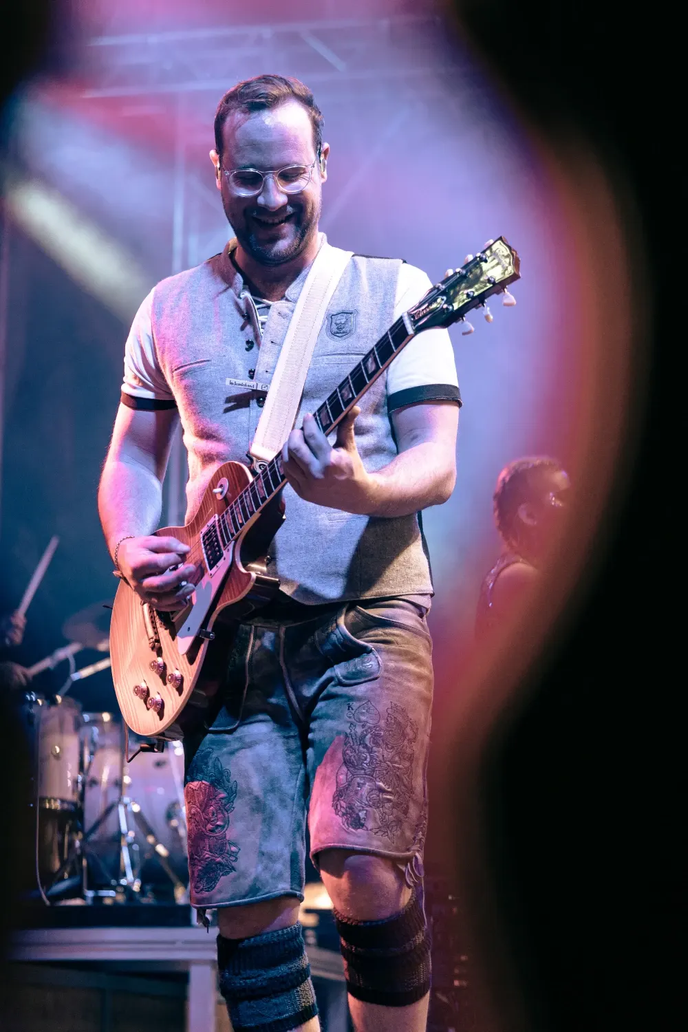 Gitarrenspiel auf der Bühne vor blauem Scheinwerferlicht