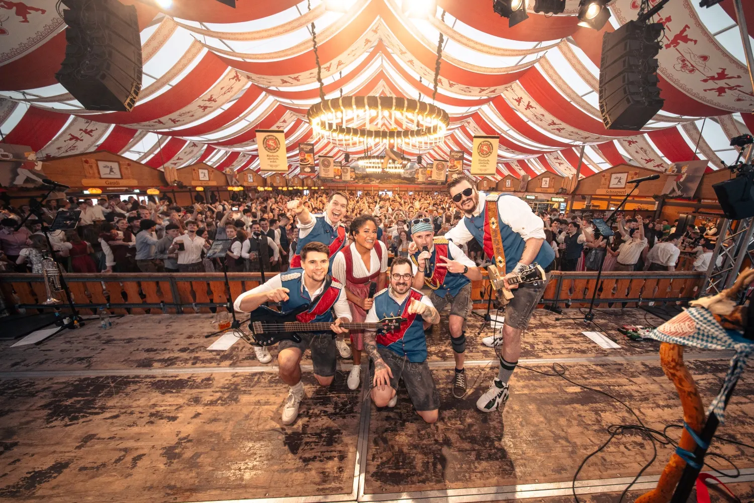 Die komplette Band auf der Bühne eines vollen Festzelts